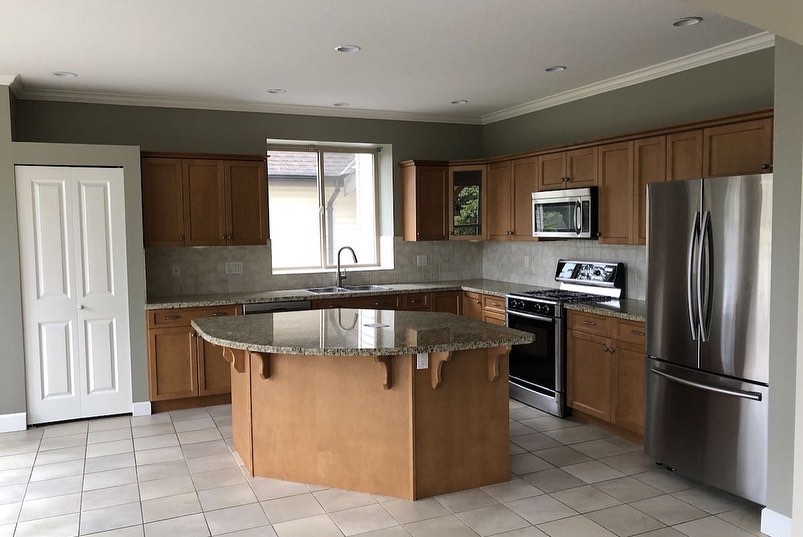 Main kitchen before renovation with older wood cabinetry and island